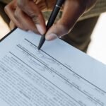 Person signing a legal document representing inheritance and estate planning