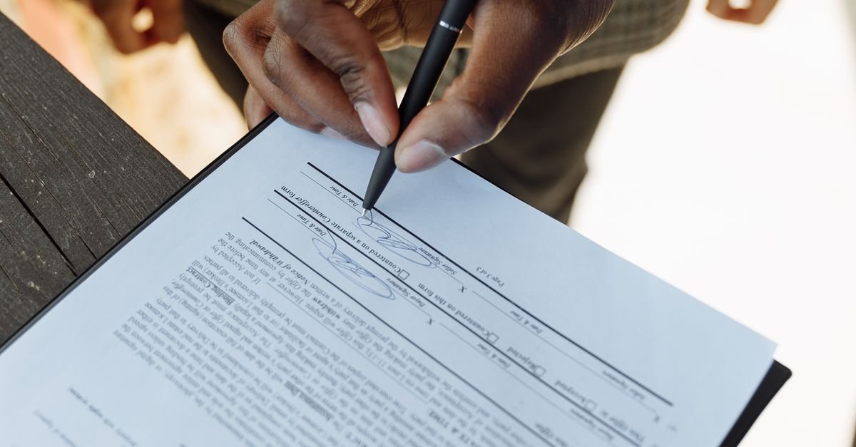 Person signing a legal document representing inheritance and estate planning