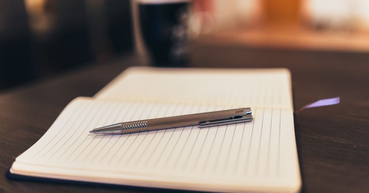 Notebook and pen representing writing down and backing up a crypto seed phrase